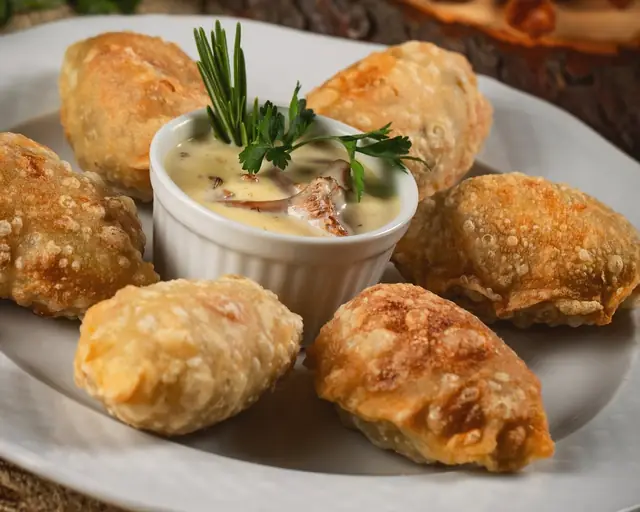 Pierogi obsmażane z kurkami i boczkiem z sosem kurkowym